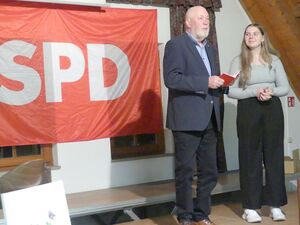 Gerhard Scheck übergibt das Parteibuch an Freya Ansbach